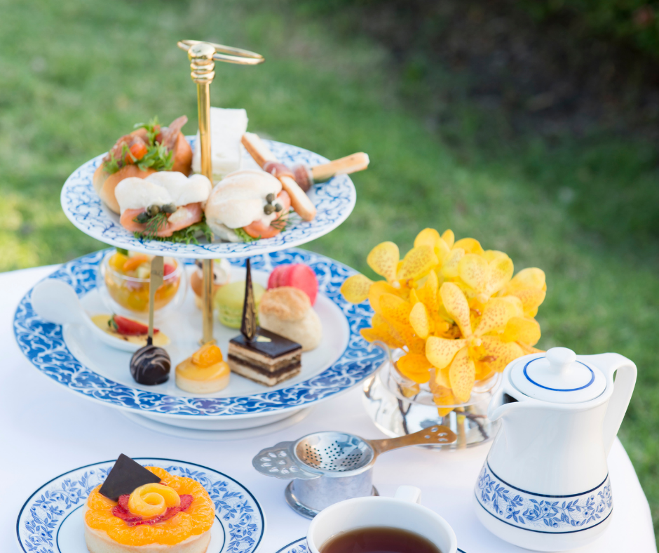 This shows a afternoon tea on a table in a garden outside,